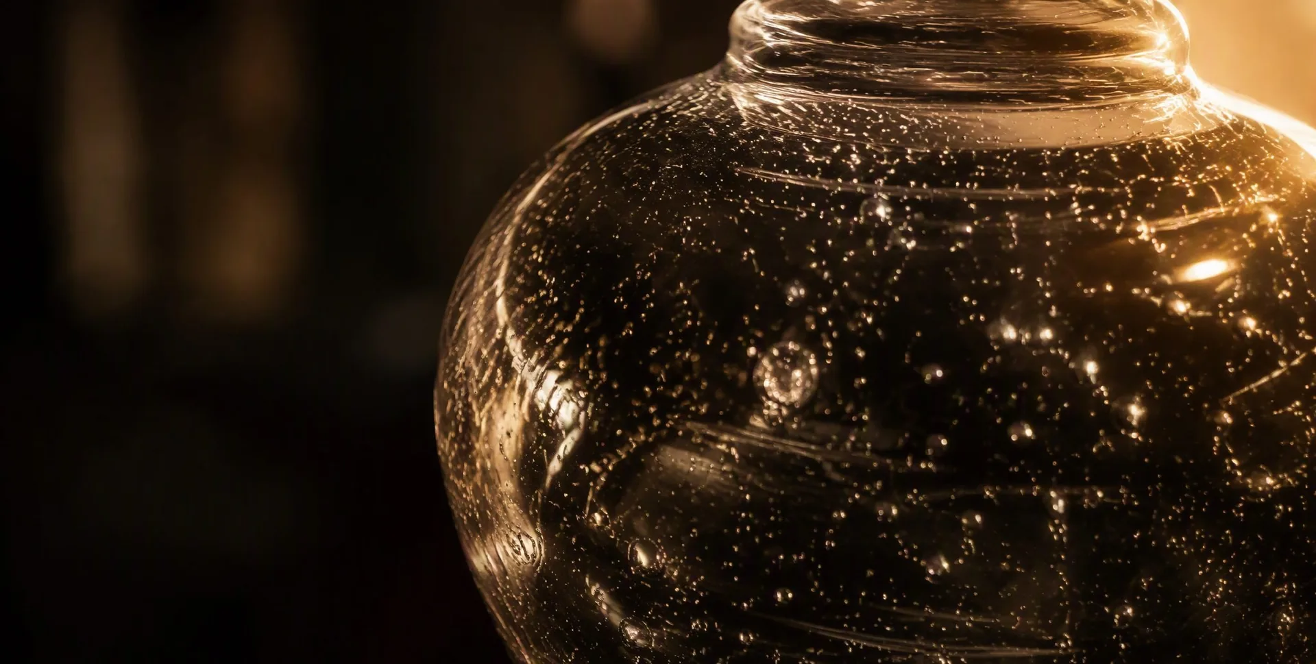 A tiny bubble captured inside a glass wall, backlit
